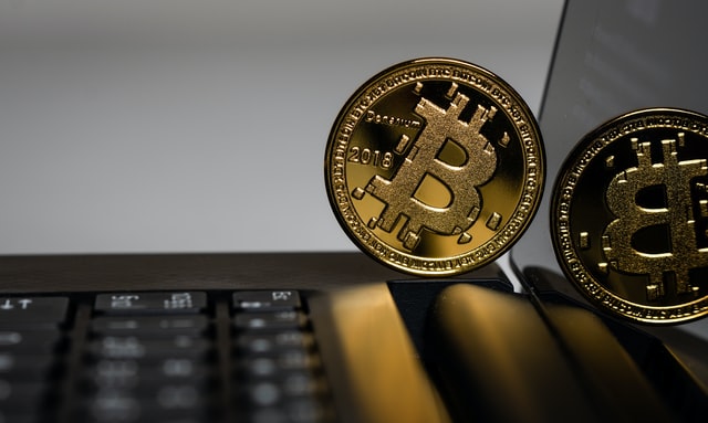 Bitcoin-kolikko kannettavan tietokoneen päällä